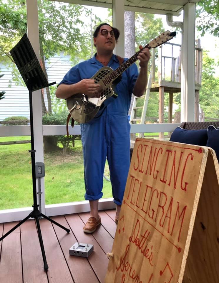 Dot Levine singing in a screened in porch while playing their nickel-played brass resonator guitar